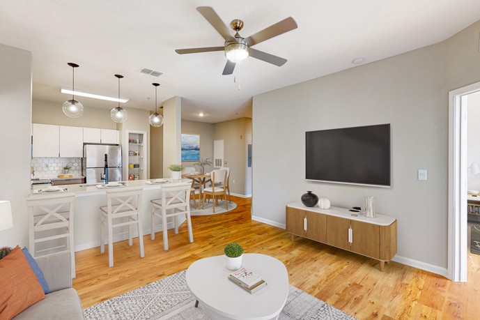 A spacious open-floor plan encompassing the living room, dining room, and kitchen, tastefully furnished and adorned with modern décor at The Enclave at Tranquility Lake, in Riverview, FL.