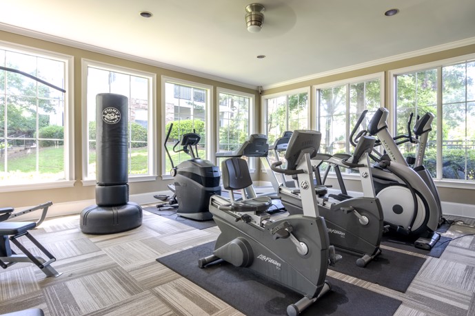  The fitness center at Reflections on Sweetwater, equipped with various exercise machines, weights, and cardio equipment.