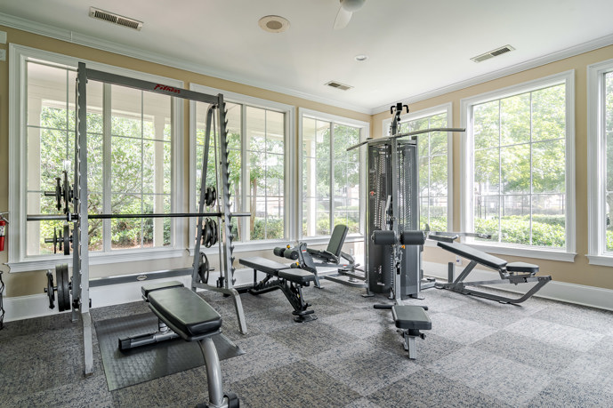  The fitness center at Reflections on Sweetwater, equipped with various exercise machines, weights, and cardio equipment.