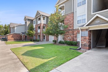 Exterior view of Carrington Place apartments in Houston, TX with driveways and patches of lawn in front of them