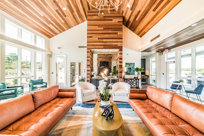 he comfortable lounge area at Virtuoso apartments' clubhouse in Huntsville, AL, featuring large windows and stylish leather seating, 