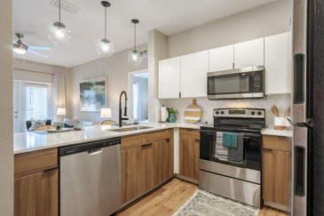 A modern kitchen at The Enclave at Tranquility Lake in Riverview, FL, featuring sleek cabinetry, stainless steel appliances, and granite countertops.