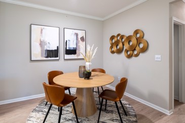The apartment dining room at The Pointe at Vista Ridge with a dining table and wall furnishings.