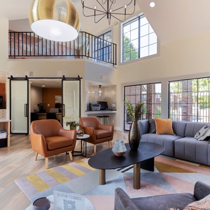 The clubhouse interior at The Augusta apartments, featuring a dedicated business center and upstairs seating area, offering residents a multifunctional space for work and relaxation.