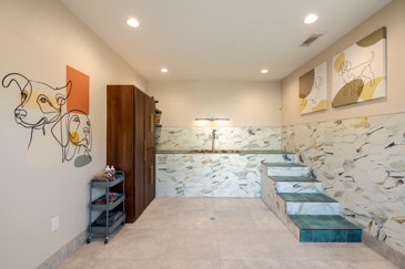The pet spa at The Pointe at Vista Ridge includes a tub and an armoire for supplies, offering convenience for residents to groom their pets.