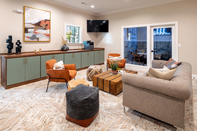 A  modern lounge room with chairs and a TV in the clubhouse at Pointe at Vista Ridge in Lewisville, Texas.