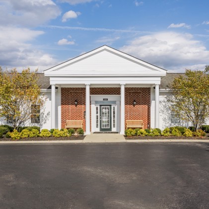 The exterior of Schirm Farms, with a brick siding and 2 white pillars. 