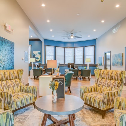 The leasing office and lobby at the 1800 at Barrett Lake apartments with decorative chairs and a circular coffee table. 