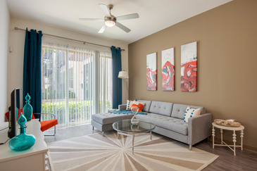 A stylish living room with large sliding glass doors to a balcony at VV&M.