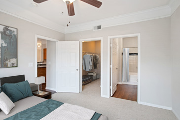 Carpeted bedroom with a door to the closet, one to the bathroom, and another to the hallway