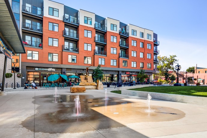 Exterior view of Patina Flats at the Foundry, highlighting the contemporary design, well-maintained landscaping, and outdoor amenities, including seating areas and green spaces