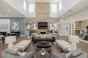 The expansive community lounge with seating, skylights, and a TV at The Chelsea.