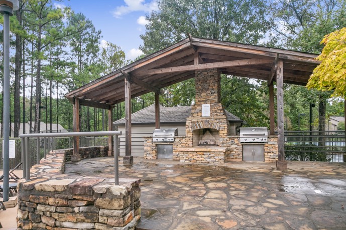 Outdoor kitchen with grill and stone fireplace at Ridge Crossings.
