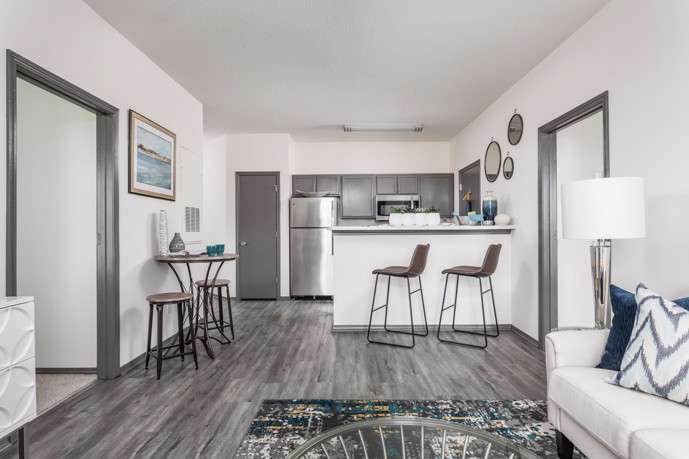 Kitchen view of a sparsely furnished  grey and white Wilmington, NC apartment with plank flooring