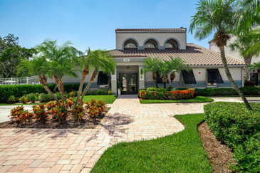 The large Spanish style clubhouse with a pathway leading to it at Vantage on Hillsborough.
