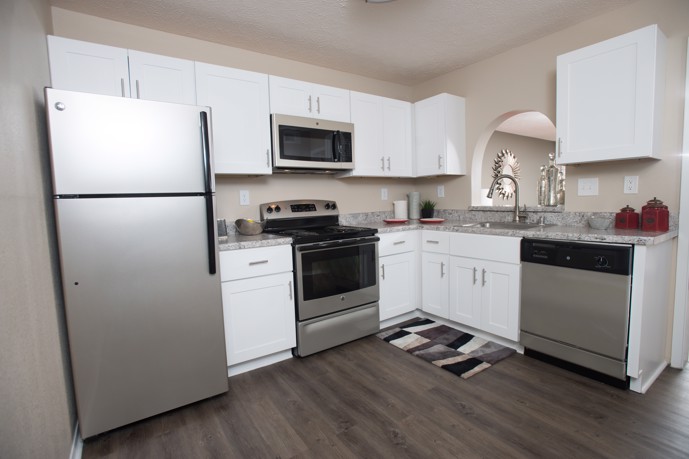 Modern kitchen with stainless steel appliances and wood floors at Ridge Crossings.