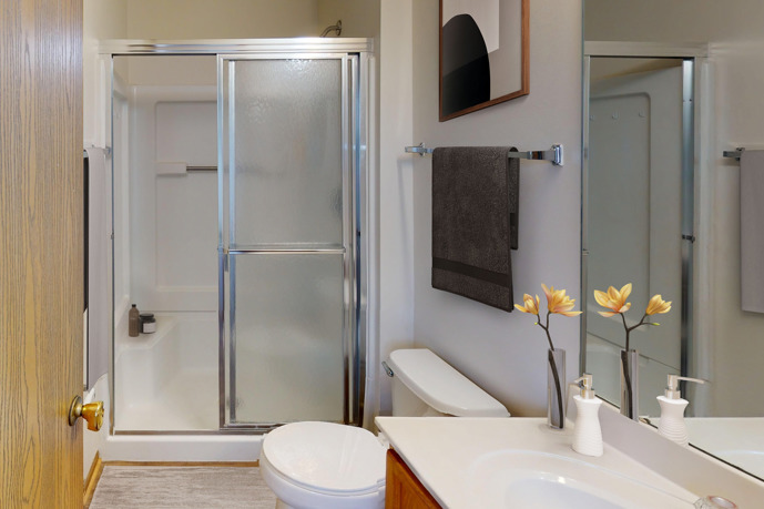 A serene bedroom featuring a large window, ample closet space, and convenient access to the hallway.