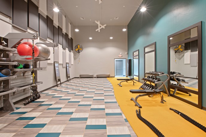 A well-equipped fitness center featuring gym equipment lining the walls and carpeted floors, providing residents with a convenient and comfortable space for their workout routines at Vantage on Hillsborough.