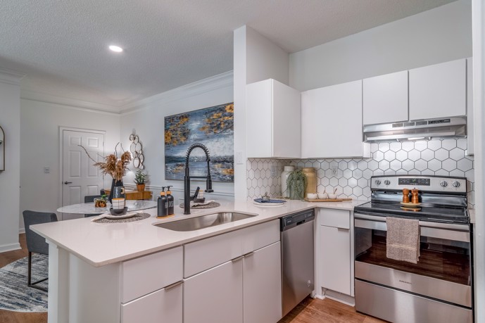 Modern kitchen featuring sleek cabinets, stainless steel appliances, and chic honeycomb tile, seamlessly connected to a cozy dining area.