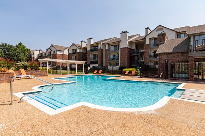 A dazzling resort-style pool surrounded by the elegant architecture of The Augusta apartments, providing residents with a luxurious outdoor oasis for relaxation and recreation.