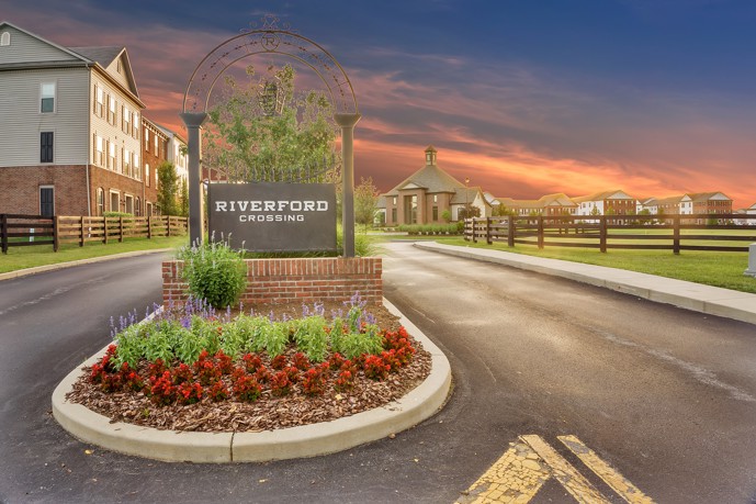 Riverford Crossing apartments entrance at dusk, with warm lights illuminating the pathway