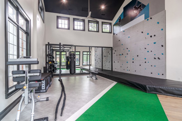 A modern and bright fitness center at Residences on McGinnis Ferry with gym equipment throughout.