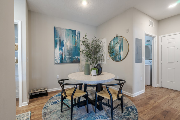 The dining room adjacent to the kitchen at The Enclave at Tranquility Lake, featuring a sturdy wooden dining table, offering residents a charming space for shared meals and gatherings.