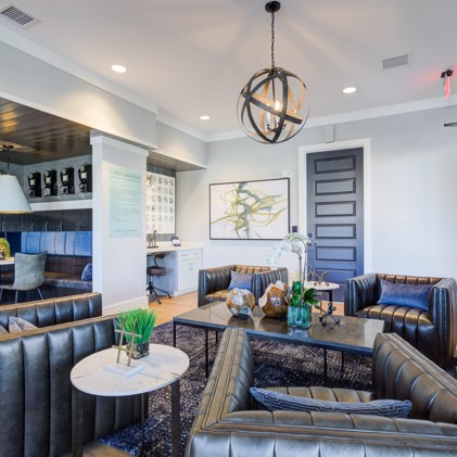 A clubhouse, where plush leather seats and a striking ball chandelier complement the adjacent dining area.