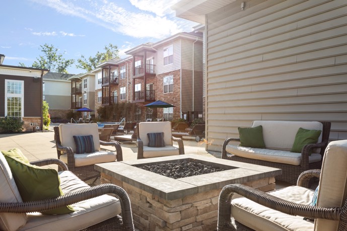 A charming outdoor fire pit area at The Chelsea apartments, complemented by cozy lounge chairs, ideal for relaxing evenings outdoors.
