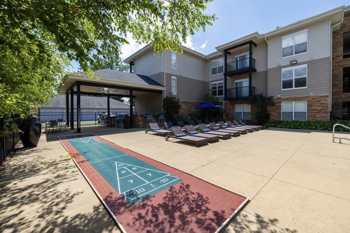 A charming outdoor grill area at The Chelsea apartments, complemented by cozy lounge chairs, ideal for relaxing evenings outdoors.