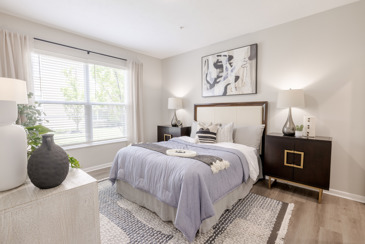 A bedroom featuring a rug, with a queen bed, and two nightstands at The Chelsea.