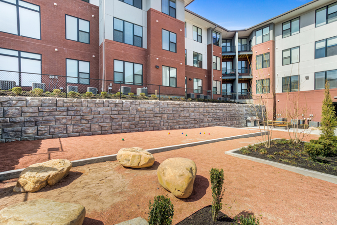 A picturesque picnic and grill area nestled within the Views of Music City in Nashville, TN, complete with a sturdy table perfect for outdoor dining amidst the lush surroundings.