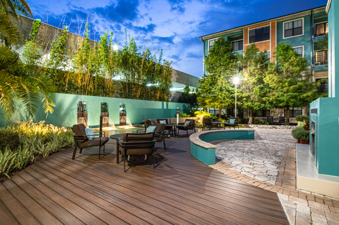 Serene swimming oasis encompassing a generous sundeck, complete with reclining lounge chairs and swaying palm trees, encircled by the architectural beauty of Millenia 700.