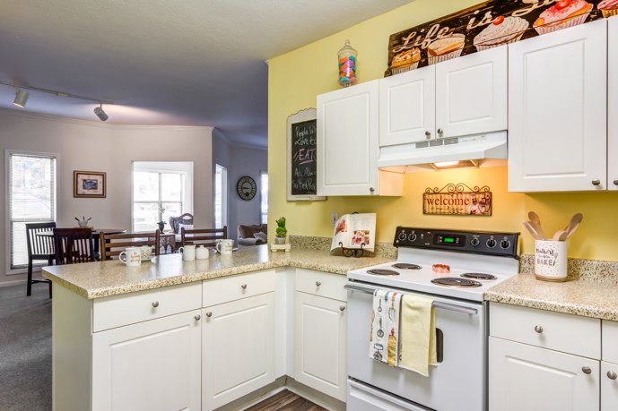 White cabinets and white stove top oven in kitchen at Sugar Mill apartments.