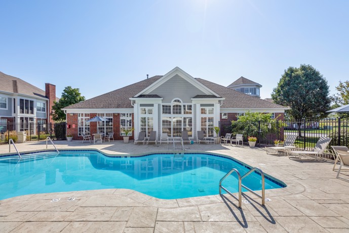 Bayview Club apartments outdoor swimming pool with a surrounding patio and buildings behind it and to the left