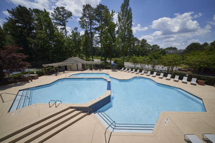 Multi Level pool overhead view at Sugar Mill apartments with pool side chairs. 