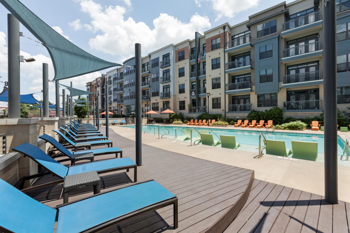 A relaxing swimming pool, hot tub, and sundeck, complete with lounge chairs and shade sails.