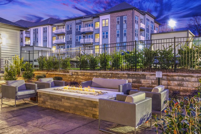 Cozy up by the firepit at Vesta City Park apartments in Charlotte, NC, surrounded by comfortable lounge seating, perfect for relaxing and enjoying the company of friends and family.