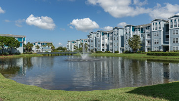 Scenic pond at The Enclave at Tranquility Lake surrounded by lush greenery and featuring a tranquil water surface reflecting the natural surroundings.