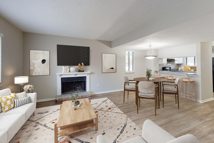 Empty open-concept apartment with wood floors and wall-to-wall carpeting with a view that faces the kitchen