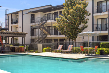 The expansive pool with loungers and orange umbrellas at the Vue at Knoll Trail.