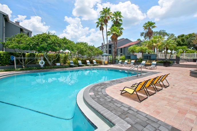 A radiant sunny day illuminates the tranquil scene at the resort-style pool area of the Vantage on Hillsborough apartments in Tampa, Florida, inviting residents to bask in the warmth and serenity.