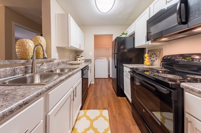 A modern kitchen with stainless steel appliances and granite counter tops at the 1800 at Barrett Lake apartments.