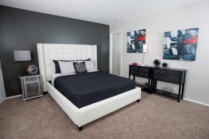 A bedroom at Ridge Crossings with a white bed and a black bedspread