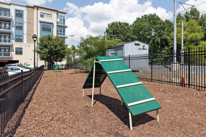 A gated community dog park adjacent to Fountain Southend's apartment building, featuring agility equipment for your furry friend.