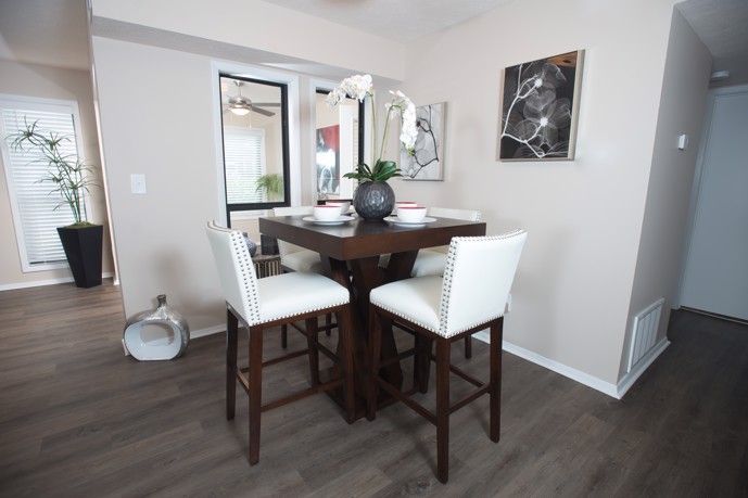 Dining room at Ridge Crossings with wood table and white chairs.