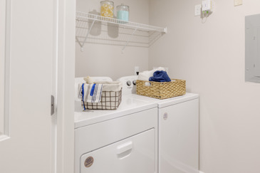 An apartment laundry room with a washer and dryer at The Chelsea.