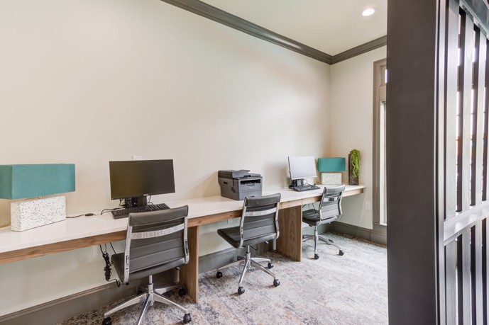 The business center at Walnut Hill apartments featuring a well-equipped computer desk, printer, and a dedicated computer available for resident use.
