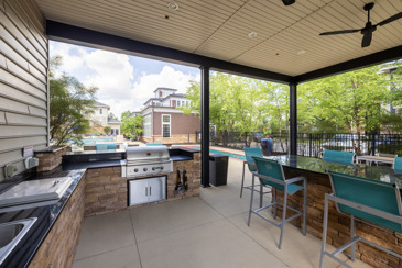 A grill station near the pool at The Chelsea with brick siding.