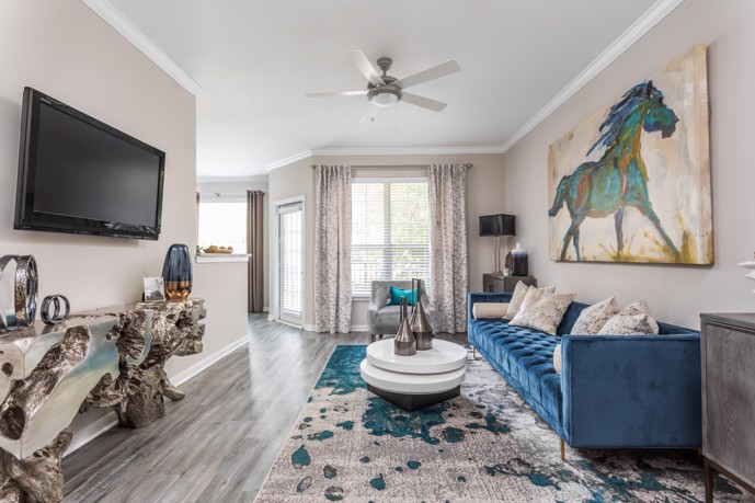 A cozy living room with comfortable seating, stylish decor, and large windows offering views of the surrounding landscape, providing a relaxing and inviting environment for residents to unwind and entertain guests.